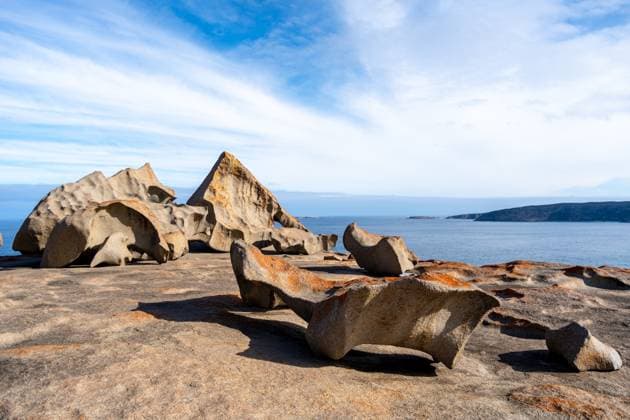 Creative Highlights World Bemerkenswerte Felsen in Flinders Chase National Park, Kangaroo Island, Australien, verfügen über einzigartige Granitformationen, die durch Wind- und Meereserosion geprägt sind, mit leuchtend orangen Flechten bedeckt sind und einen atemberaubenden Kontras Remarkable Rocks in Flinders Chase National Park, Kangaroo Island, Australia, feature unique granite formations shaped by wind and sea erosion, covered in vibrant orange lichen, creating a stunning contrast against the deep blue ocean (License=RF) Copyright: xZoonar.com LaurentxDavoustx 23641235