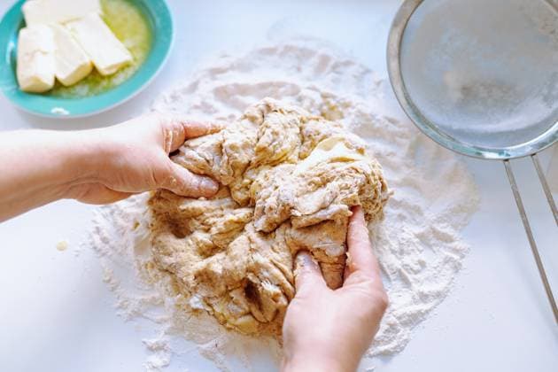 Weibliche Hände kneten Teig Women s hands, in flour, knead yeast dough for pastries, on kitchen table, sprinkled with flour, nearby there is butter on plates, colander for sifting flour (License=RF) Copyright: xZoonar.com LarysaxStefaniukx 23643962