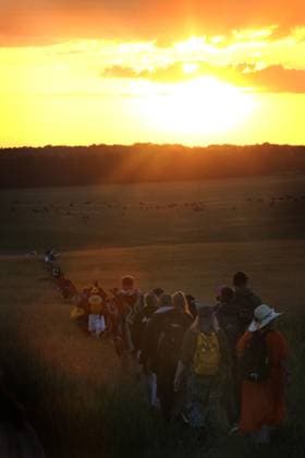 June 21, 2025, Salisbury, England, UK: Visitors walk towards the sun as it rises during the ceremony at Stonehenge. On the longest day of the year thousands of revellers gather at Stonehenge in Wiltshire, to celebrate the Summer Solstice. Neo Druids, Pagans and non-believers congregate around the 5000-year-old stone circle to celebrate the sunrise. The sun rises in perfect alignment with the Heel Stone and Altar Stone proving that ancients in the construction of the stones understood the solar calendar. Salisbury UK - ZUMAmp3_ 20250621_zip_mp3_011 Copyright: xMartinxPopex