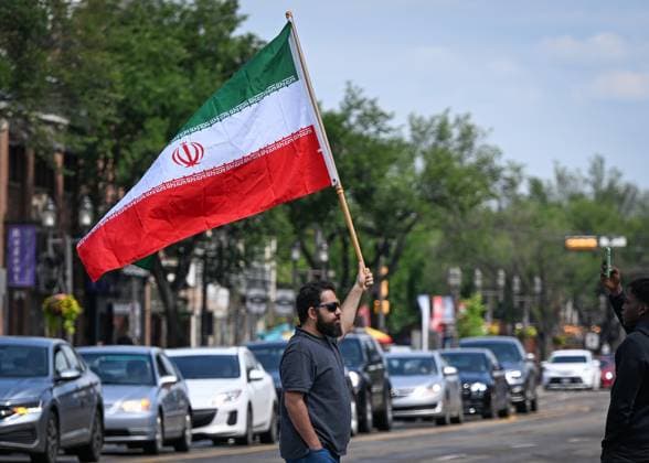 Woman With Israeli Flag Attacked During Edmonton Pro-Palestine Protest EDMONTON, CANADA JUNE 22: A protester holds an Iranian flag as members of the local Palestinian diaspora, joined by Iranian and other Middle Eastern Muslim protesters, along with local activists, gather on White Avenue in Edmonton for the Hands Off Palestine, Iran, Syria, Yemen, Lebanon protest on June 22, 2025, in Edmonton, Alberta, Canada. Edmonton Canada Copyright: xArturxWidakx originalFilename: widak-womanwit250622_npPft.jpg