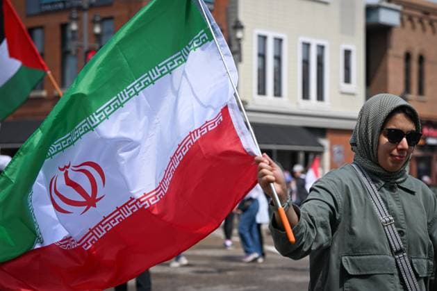 Woman With Israeli Flag Attacked During Edmonton Pro-Palestine Protest EDMONTON, CANADA JUNE 22: A protester holds an Iranian flag as members of the local Palestinian diaspora, joined by Iranian and other Middle Eastern Muslim protesters, along with local activists, gather on White Avenue in Edmonton for the Hands Off Palestine, Iran, Syria, Yemen, Lebanon protest on June 22, 2025, in Edmonton, Alberta, Canada. Edmonton Canada Copyright: xArturxWidakx originalFilename: widak-womanwit250622_npZ8M.jpg