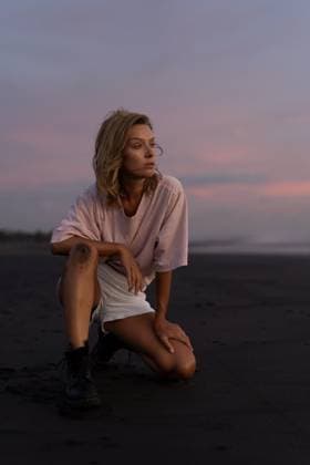 Creative Highlights Symbolbilder Stylish young woman kneeling on a black sand beach at dusk Kuta Utara, Bali, Indonesia CR_YUKI250620-1770389-01 ,model released, Symbolfoto