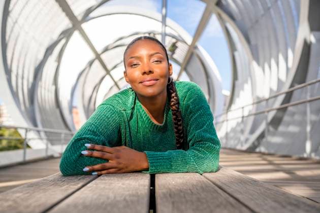 Creative Highlights Symbolbilder Confident young woman lying on footbridge model released, Symbolfoto, DLTSF03463