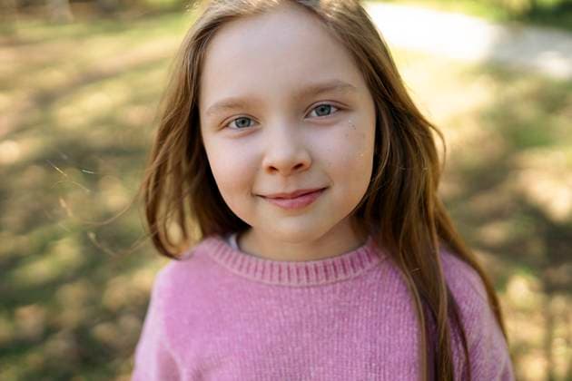 Creative Highlights Symbolbilder Joyful girl in a pink sweater smiling outdoors on a sunny day model released, Symbolfoto, VCF00756