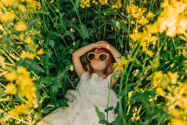 Creative Highlights Symbolbilder Girl in white dress with sunglasses smiling in a rapeseed field model released, Symbolfoto, VSNF03315