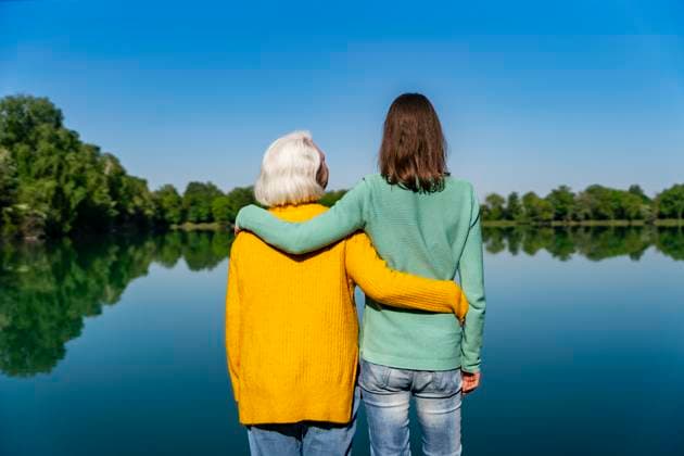 Creative Highlights Symbolbilder Mother and daughter embracing by a lake on a jetty enjoying nature and relaxation model released, Symbolfoto, DIGF24530