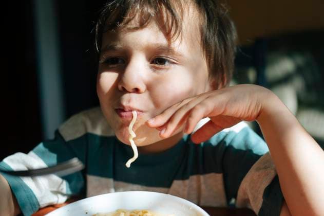 Creative Highlights Symbolbilder Child enjoying noodles at home during lunch model released, Symbolfoto, ANAF04717