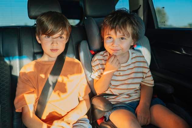 Children sitting in a car wearing seat belts during a family road trip model released, Symbolfoto, ANAF04739