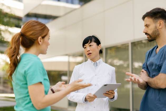 IMAGO Creative, Diversity, Pflege im Krankenhaus Medical team discussing healthcare strategies outdoors with a digital tablet model released, Symbolfoto, FLMZF00857