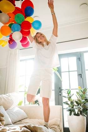 Creative Highlights Symbolbilder Girl dancing joyfully with balloons in a bright living room model released, Symbolfoto property released, MDOF02881