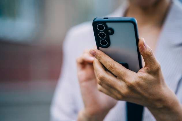 Woman holding smartphone in urban setting model released, Symbolfoto, ANAF04789