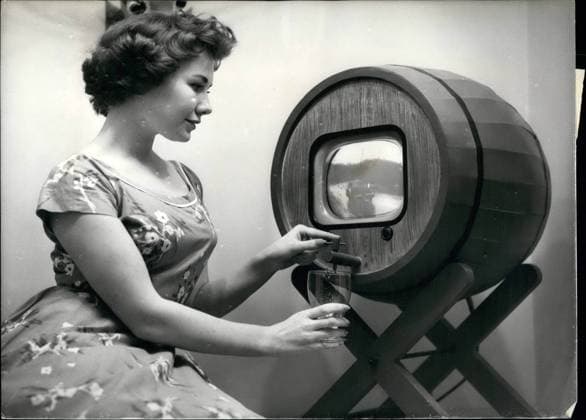 Radio 8. August 1958 - Vorschau auf die Radiosendung im Earls Court. Das Foto zeigt Julia Rose, 19, aus Stanmore, abgebildet mit diesem neuartigen Fernseher in einem Fass, einem der neuesten Features der Show, die morgen eröffnet wird. *** Radio 8 August 1958 Preview at the Radio broadcast at Earls Court the Photo shows Julia Rose, 19, from Stanmore, illustrated with this new type of Television in a Barrel, a the latest Features the Show, the Tomorrow opened will  Copyright: xUnitedxArchivesx xkpaxKeystonex 19580808_baf_k09_190