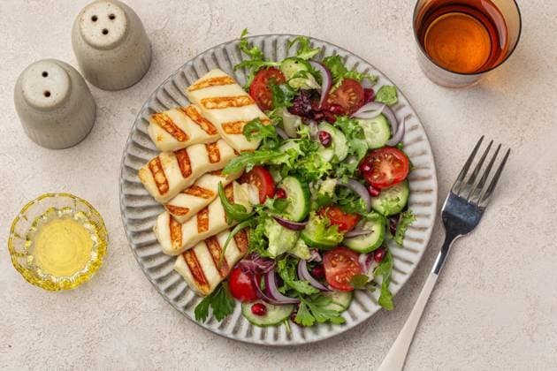 gebratener Halloumi-Käse mit frischem Gemüsesalat auf Keramikteller, Draufsicht, heller Hintergrund fried halloumi cheese with fresh vegetable salad on ceramic plate, top view, light background (License=RF) Copyright: xZoonar.com Anna_Shepulovax 23664319