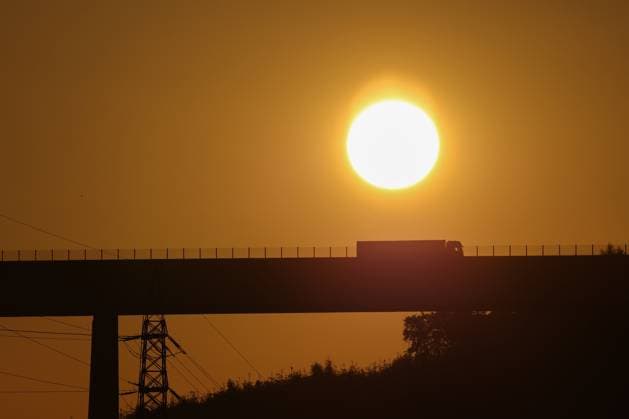 Die naechsten (nächsten) Tage soll es heiss (heiß) werden in NRW. Eine Hitzewelle rollt an. Der Tag beginnt. Sonnenaufgang ueber (über) der Siegtalbruecke (Siegtalbrücke) in Eiserfeld. Ueber (Über) die Bruecke (Brücke) faehrt (fährt) ein Lastwagen. Sommer im Siegerland am 30.06.2025 in Siegen Deutschland.