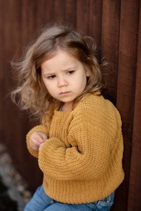 Creative Highlights Symbolbilder Thoughtful toddler girl leaning against the fence and gazing sideways. Corby, England, United Kingdom R_JNDO250628A-1767274-01 ,model released, Symbolfoto