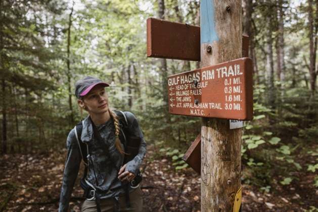 Creative Highlights Symbolbilder Female hiker looks at trail sign to Gulf Hagas in the Maine woods. Brownville, Maine, United States R_SSNF250629B-1768937-01 ,model released, Symbolfoto