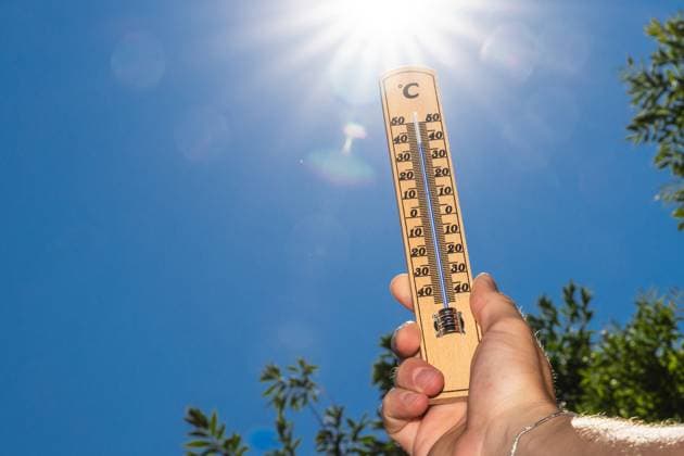 Ein Thermometer vor greller Sonneneinstrahlung zeigt Temperaturen nahe 40 Grad dieses Motiv symbolisiert drückende Hitze und die Intensität extremer Sommertage.