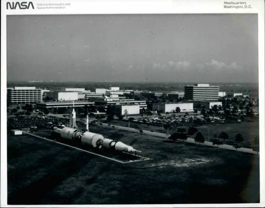 Astronaut Kometen NASA Weltraum Raumschiff UFOs 1982 – Johnson Space Center, Houston, Texas. JSC-Luftaufnahme – Diese nordöstliche Ansicht des Johnson Space Center wurde im Dezember 1982 von einem Fotografen an Bord eines tieffliegenden NASA-Flugzeugs aufgenommen. Viele der Einrichtungen im zentralen Bereich des NASA-Zentrums in Houston sind zu erkennen. Im Vordergrund sind eine Saturn-V-Trägerrakete sowie Modelle einer Mercury-Redstone- und einer Little-Joe-Rakete zu sehen. Die fensterlose Anlage, das zweite Gebäude von links in der Bildmitte, ist das Missionskontrollzentrum. Das neunstöckige Gebäude rechts in der Mitte ist die Projektmanagement-Einrichtung. Das Ufer des Clear Lake ist oben rechts teilweise sichtbar. *** Astr  Copyright: xUnitedxArchivesx xkpaxKeystonex 19600108_baf_k09_1273