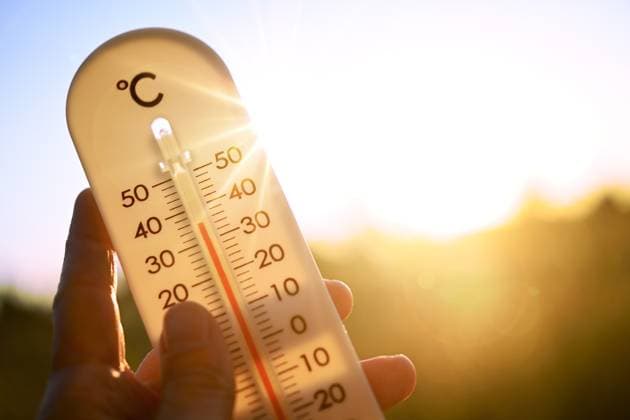 FOTOMONTAGE, Thermometer im Gegenlicht zeigt hohe Temperaturen an