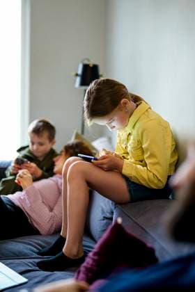 IMAGO Creative, Lifestyle, Gaming Full length of girl playing games on smart phone while sitting on sofa at home Sweden, Stockholm, model released, property released Copyright: xMaskotx , MA118172 MA118172