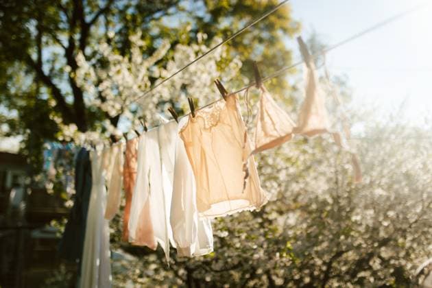 Creative Highlights Symbolbilder Clothes drying on a sunny clothesline in nature A picturesque scene of delicate garments hanging on a clothesline, gently swaying in the sunlight amidst blooming trees, capturing the essence of natural freshness and tranquility Model Released CamilleGirard_ID29280_953354_006 Copyright: xCamillexGirardx