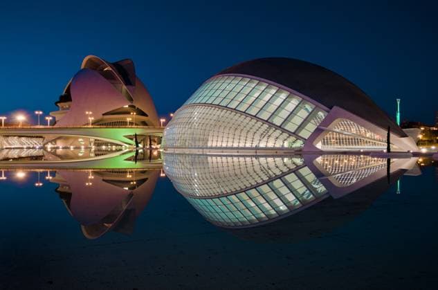 An evening view of the iconic City of Arts and Sciences in Valencia, Spain, showcasing the futuristic architecture beautifully reflected in the tranquil water under the blue sky Model Released CesarAsensio_ID28530_838857_008 Copyright: xCesarxAsensiox RECORD DATE NOT STATED