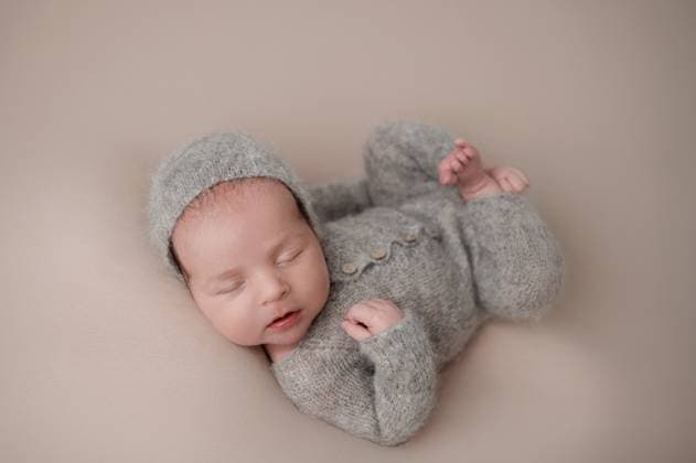 Creative Highlights Symbolbilder MR_ID29187_21322_AlexandrLevshunov.jpg A serene newborn baby peacefully sleeps in a cozy gray knitted outfit, exuding warmth and innocence. The soft fabric adds a touch of comfort and tranquility to the scene Model Released KatrinPrimak_ID29187_891137_006 Copyright: xKatrinxPrimakx