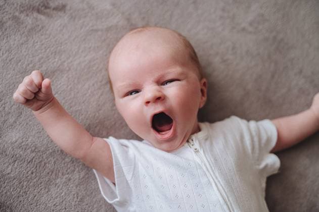 Creative Highlights Symbolbilder One month old newborn baby wearing a white outfit, captured mid yawn while lying on a soft, neutral colored surface, exuding pure sweetness and serenity. Model Released KatrinPrimak_ID29809_1007482_010 Copyright: xKatrinxPrimakx