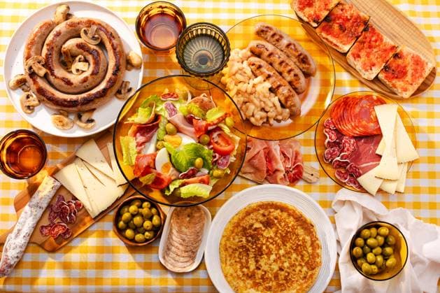 IMAGO Creative, Food, Tapas A vibrant table spread with a traditional Catalan salad, botifarra with mushrooms, olives, spanish jam, cheese, and a tortilla with potatoes Model Released MariaShchipakina_ID29079_888164_001 Copyright: xMariaxShchipakinax RECORD DATE NOT STATED