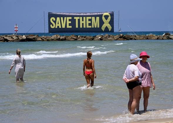 Bilder des Jahres 2025, News 07 Juli News Themen der Woche KW27 A banner calling for the release of Israeli hostages still held by Hamas in Gaza since October 7, 2023, is displayed in the Mediterranean Sea in front of the U.S. Embassy branch in Tel Aviv on Friday, July 4, 2025. Released hostages joined families whose loved ones are held in Hamas captivity in a protest calling on U.S. President Donald Trump to bring all the hostages home and end the war.  JER2025070402 DEBBIExHILL