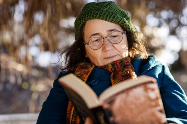 MR_ID29447_21544_BaharCetin.jpg A middle-age woman dressed warmly in a coat, scarf, and hat, enjoys reading a book while sitting outdoors in a serene countryside setting during cold weather Model Released Selena3726_ID29447_1005891_001 Copyright: xSelena3726x RECORD DATE NOT STATED