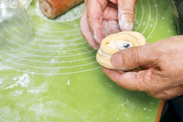 MR_ID29877_21586_NataliaRadayeva.jpg Hands crafting homemade buns with a creamy cottage cheese filling, ready for baking. The rustic kitchen ambiance enhances the appeal of these delicious pastries Model Released SvetlanaRadayeva_ID29877_1008896_002 Copyright: xSvetlanaxRadayevax