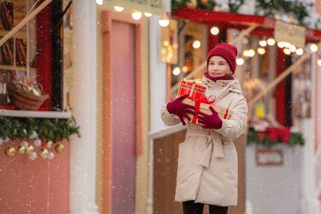 girl carrying gifts walks along shopping arcade of Christmas market. Saint Petersburg, Saint Petersburg, Russia CR_YFCG250703-1777175-01 ,model released, Symbolfoto