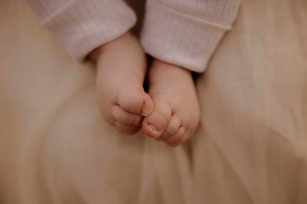 Creative Highlights Symbolbilder Close-up of baby legs and feet against soft beige fabric Amsterdam, North Holland, Netherlands R_RTBZ25070391-1777414-01