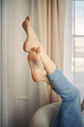 Creative Highlights Symbolbilder Unerkennbare Frau, die ihre Füße in die Luft hebt, während sie auf einem weichen Stuhl in einem Haus sitzt Unrecognizable woman raising her feet in the air while seated on a soft chair indoors Copyright: imageBROKER AlekseixIsachenko ibxaii14042586.jpg ,model released, Symbolfoto ,property released