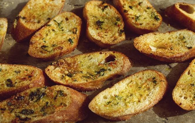 Baguette Toasts, im Ofen gebacken, mit Knoblauchbutter und Kräutern, hausgemacht, auf einer Platte, Ansicht von oben Baguette toasts, baked in the oven, with garlic butter and herbs, homemade, on a platter, top view Copyright: imageBROKER xDidebashvili ibxgai14305351.jpg