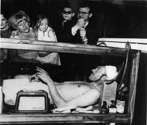 5. Mai 1966 – Fakirs Heldentaten: Fakir Tchandra plant, mehr als 90 Tage in einer Kiste in Begleitung von 40 VIPs zu verbringen. Die Kiste hat die Form eines Sarges mit Glaswänden und enthält einige Flaschen Mineralwasser, Streichhölzer und Zigaretten sowie eine Flasche Äther, Alkohol und Eau de Cologne – denn man weiß nie, was passieren kann, wenn man auf einem Bett aus zerbrochenen Flaschen liegt. Foto: Fakir Tchandra in seiner sargähnlichen Kiste, beim Reifen, um seinen bisherigen Rekord zu übertreffen. (Bildnachweis: Keystone Press Agency ZUMA Press Wire) *** 5 May 1966 – Fakirs Heroic deeds Fakir TCHANDRA plans, more as 90 Days in a Box in Support from 40 VIPs to spend the Box  Copyright: xUnitedxArchivesx xkpaxKeystonex 19660505_baf_k09_096