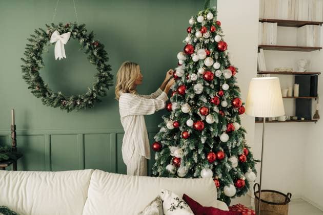 Elegante junge Frau schmückt einen Weihnachtsbaum in einem Schlafzimmer Wohnzimmer Interieur Elegant young woman decorates a Christmas tree in a bedroom living room interior Copyright: imageBROKER TITOVAxILONA ibxiqx14180874.jpg ,model released, Symbolfoto ,property released