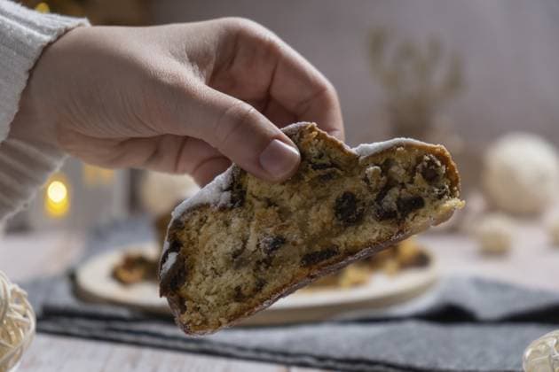 Weibliche Hand, die ein Stück von hausgemachten Weihnachten traditionellen Kuchen Kuchen mit Marzipan Nüsse und getrocknete Früchte Gebäck Dessert Stollen. Winterferien Saison Atmosphäre. Leckere leckere Zusammensetzung nach Hause Tisch Einstellung Textfreiraum Female hand taking slice of Homemade Christmas traditional cake pie with marzipan nuts and dried fruits pastry dessert stollen. Winter holidays season atmosphere. Delicious tasty composition home table setting Copy space Copyright: imageBROKER AnastasiiaxYanishevs ibxiqx14048650.jpg