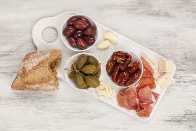 IMAGO Creative, Food, Tapas Tapas von oben. Getrocknete Tomaten, Kapern, Oliven, Käse und Prosciutto Schinken. Italienisches Vorspeisen Konzept Tapas from above. Dry tomatoes, capers, olives, cheese and prosciutto ham. Italian appetizer concept Copyright: imageBROKER Eskymaks ibxiqx13960291.jpg