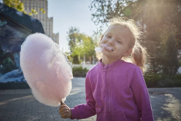 Lockenköpfiges Mädchen ißt begeistert Zuckerwatte. Das Konzept einer Familie mit Kindern und das Glück mit Kindern Curly-haired girl enthusiastically eats cotton candy. The concept of a family of children and happiness with children Copyright: imageBROKER TatyanaxKutina ibxiqx14275776.jpg ,model released, Symbolfoto ,property released