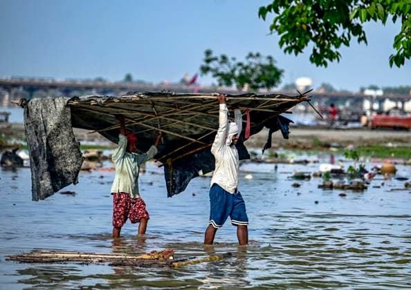 News Themen der Woche KW28 India, Weather, Floods Vendors shift their belongings to a dry area on the banks of the River Ganges in Prayagraj, India on July 13, 2025, as water levels of the Ganges and Yamuna rivers rose following monsoon rainfalls. Prayagraj Uttar Pradesh India Copyright: xSanjayxKanojiax