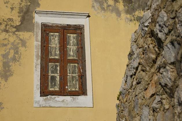 IMAGO Creative, Herbst, Reiseziel, Dodekanes, Griechische Inseln Ein altes, verwittertes Fenster in einer gelben Wand, neben einer Steinmauer mit Flecken, Symi Stadt, Symi, Dodekanes, Griechische Inseln, Griechenland, Europa An old, weathered window in a yellow wall, next to a stone wall with stains, Symi Town, Symi, Dodecanese, Greek Islands, Greece, Europe Copyright: imageBROKER RalfxAdler ibxraa13828437.jpg