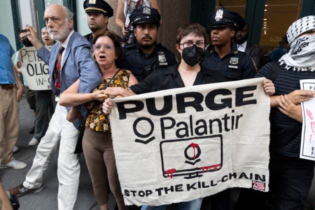 July 14, 2025, New York, New York, USA: Demonstrators with Planet Over Profit hold a sign that reads PURGE PALANTIR STOP THE KILL-CHAIN while blockading the entrance to the software company Palantir denouncing their work with U.S. Immigration and Customs Enforcement (ICE) and weapons manufacturers. In ManhattanÃ¢â‚¬â ¢s Chelsea neighborhood protesters call for Palantir to stop supplying tech that supports Trump administration tracking of migrants for deportation and weapons used by Israel in Gaza. Multiple demonstrators are arrested by NYPD. New York USA - ZUMAr174 20250714_znp_r174_004 Copyright: xGinaxMxRandazzox