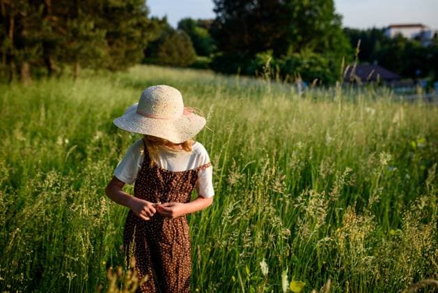Creative Highlight Symbolbilder Child walking through tall grass in countryside. Child walking through tall grass in countryside, peaceful childhood moment. model released