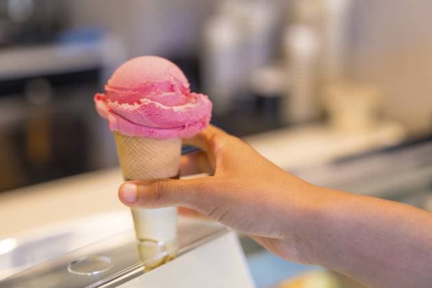Ein Kunde wählt eine köstliche rosa Eistüte aus einer gut gefüllten Kühlvitrine in einer charmanten Gelateria Customer selecting a delightful pink ice cream cone from a well stocked refrigerated display case in a charming gelateria Copyright: imageBROKER UnaixHuizi ibxuhu13965175.jpg ,model released, Symbolfoto ,property released