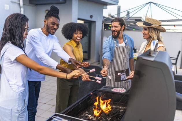 Glückliche Freunde, die auf dem Dach grillen, Marshmallows über glühenden Flammen rösten und dabei lachen und bleibende Erinnerungen schaffen Happy friends enjoying a rooftop barbecue, roasting marshmallows over glowing flames while sharing laughter and creating lasting memories Copyright: imageBROKER UnaixHuizi ibxuhu14211781.jpg ,model released, Symbolfoto ,property released