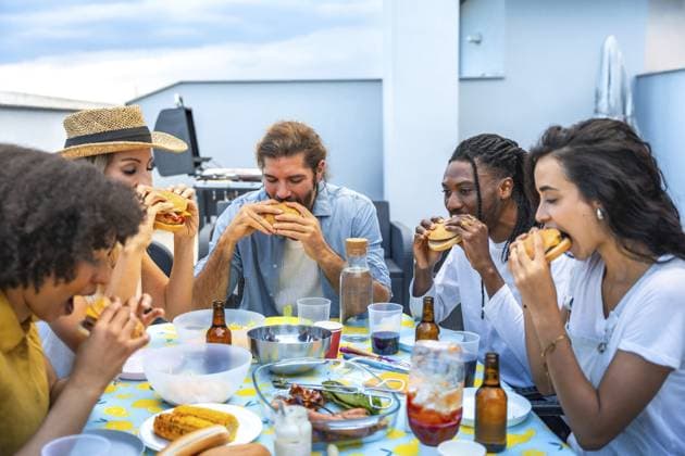 Fröhliche multiethnische Freunde genießen leckere Burger bei einer lebhaften Grillparty auf dem Dach und feiern gemeinsam den Sommer Cheerful multi ethnic friends savoring delicious burgers while enjoying a lively rooftop barbecue party, celebrating summer together Copyright: imageBROKER UnaixHuizi ibxuhu14211837.jpg ,model released, Symbolfoto ,property released