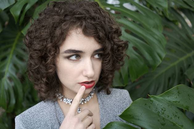 Creative Highlight Symbolbilder Woman with curly hair and a necklace is looking at the camera. She is wearing a gray jacket and a red necklace Woman with curly hair and a necklace is looking at the camera. She is wearing a grey jacket and a red necklace Copyright: imageBROKER EkaterinaxPereslavts ibxiqx14294033.jpg ,model released, Symbolfoto ,property released