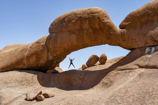 Touristin springt in einem Felsbogen, runde Felsformationen mit Steinbogen, Pontok-Berge, Große Spitzkoppe, Spitzkoppe, Große Spitzkuppe Nature Reserve, Namibia Tourist jumping in a rock arch, round rock formations with stone arch, Pontok Mountains, Great Spitzkoppe, Spitzkoppe, Great Spitzkoppe Nature Reserve, Namibia Copyright: imageBROKER MoritzxWolf ibxmmw13647835.jpg ,model released, Symbolfoto ,property released